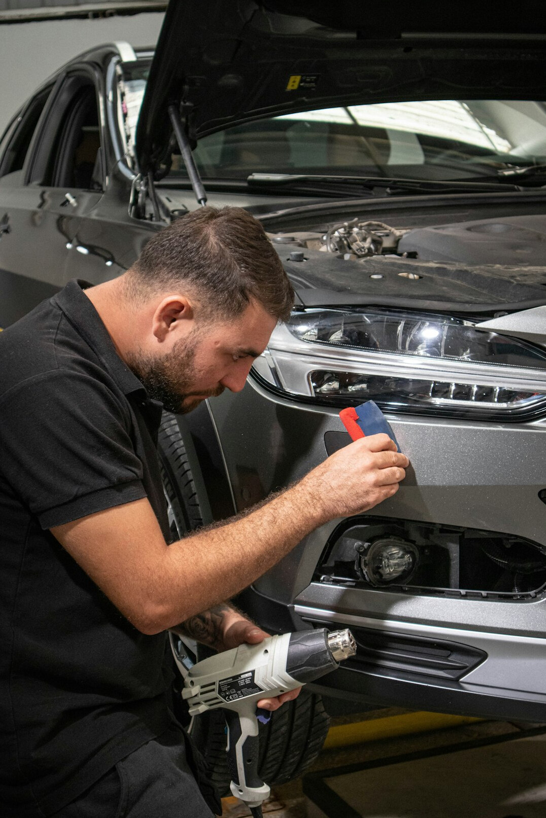 Mechanic inspecting a car engine in a garage